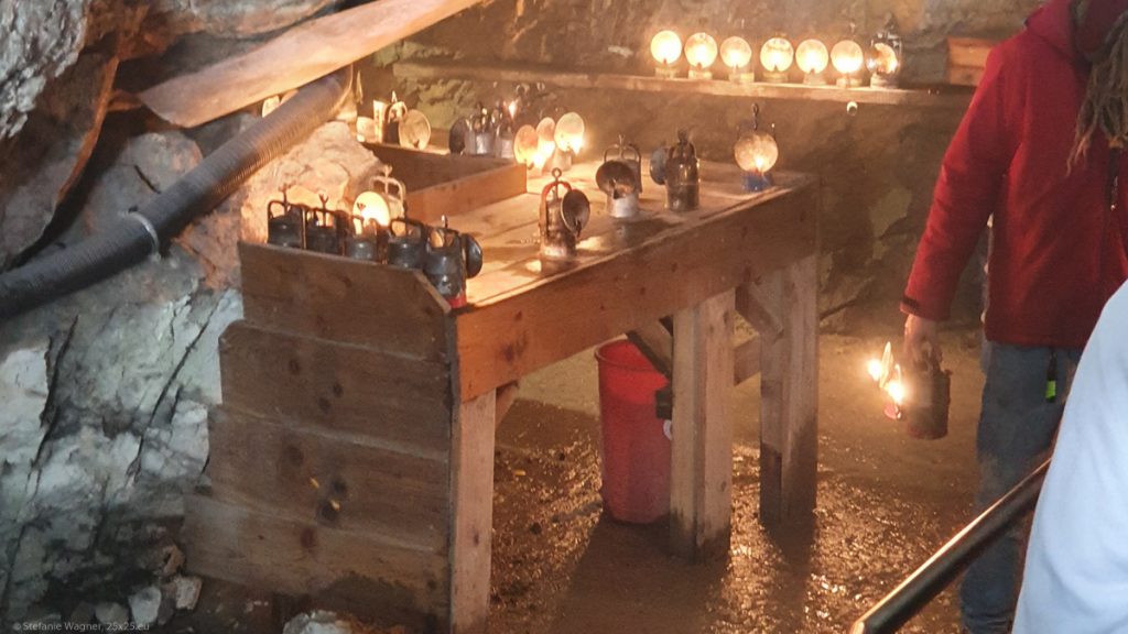 A wooden table with multiple carbide lamps on it.