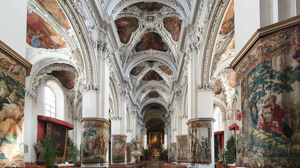 Interior of the church: white walls with colorful paintings and a lot of white ornaments
