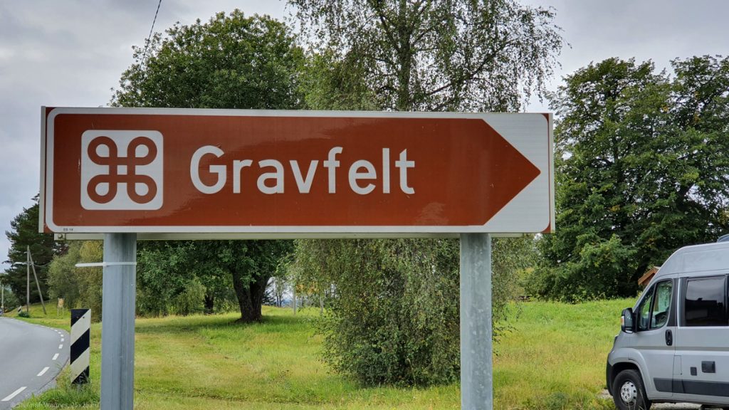 Brown sign saying "Gravfelt" with the curved symbol next to it