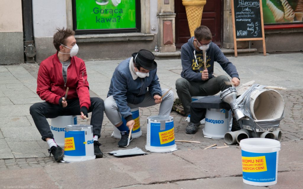 3 street musicians playing drums on old buckets