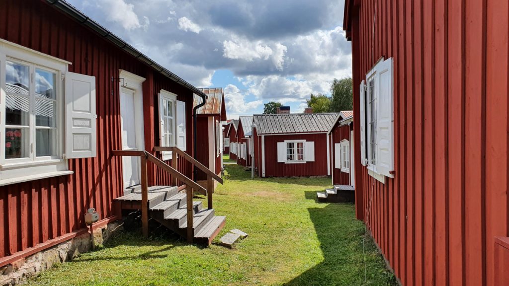 Small red wooden houses, lawn between them (no street)