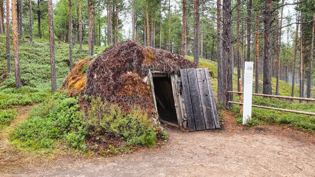 Very small, round hut, covered with moss, wooden door